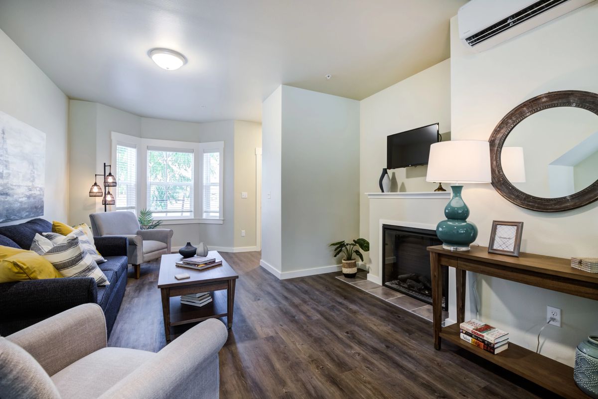 A cozy living room with modern decor, featuring a fireplace and hardwood flooring.
