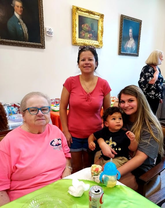 A family gathering with several people posing for a group photo indoors.