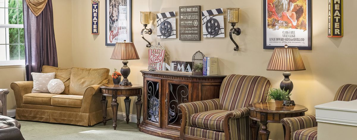 A cozy living room corner with a striped armchair, decorative cabinet, and wall art.