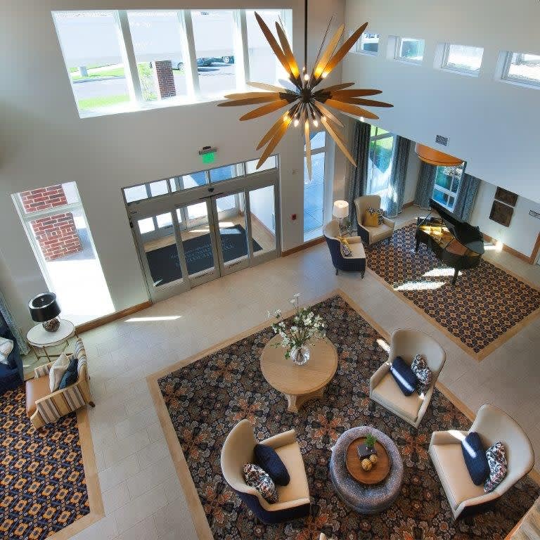 A modern lobby featuring stylish furniture and a unique chandelier.