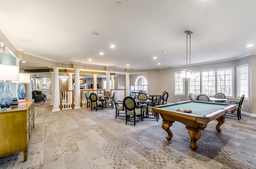 A spacious game room featuring a pool table and seating area.