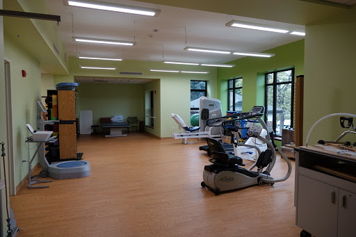 A spacious and well-lit rehabilitation gym with various exercise equipment.