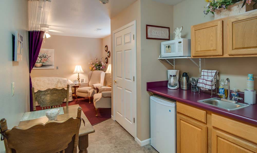 A cozy kitchenette and living room area with compact appliances and comfortable seating.