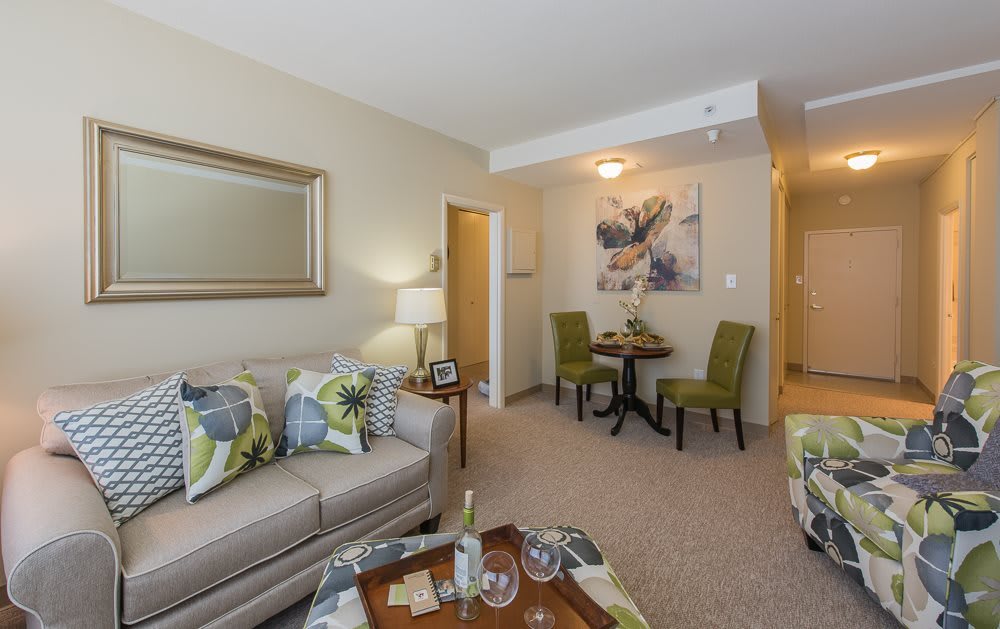A cozy living room with a sofa, chairs, and decorative elements such as pillows and artwork.