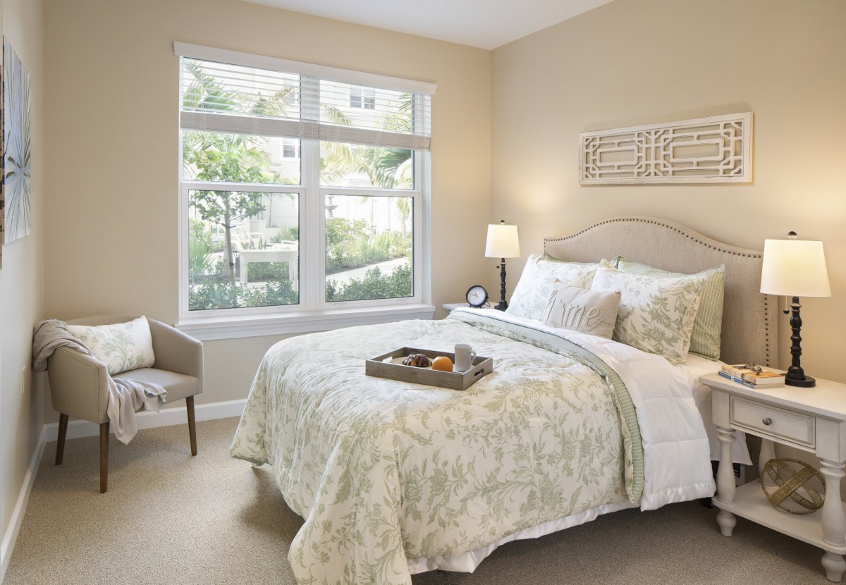 A cozy and well-lit bedroom with elegant decor and a large window.