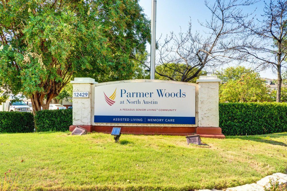 Entrance sign for Parmer Woods at North Austin surrounded by greenery.