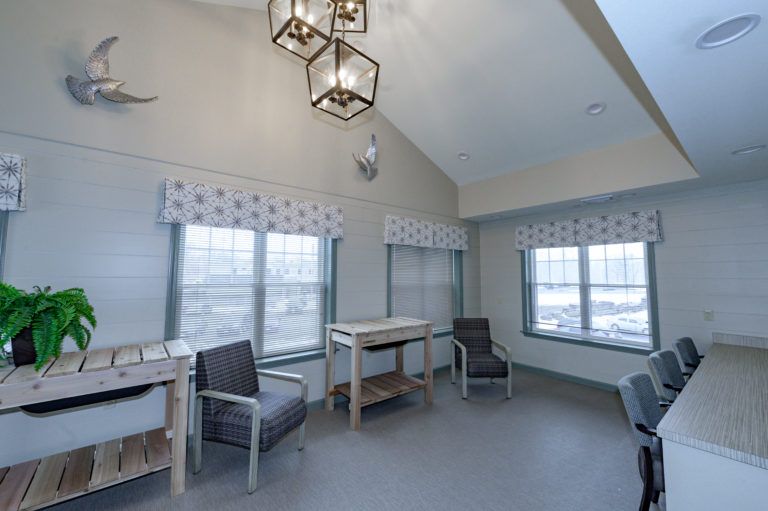 A modern waiting room with large windows and comfortable seating.