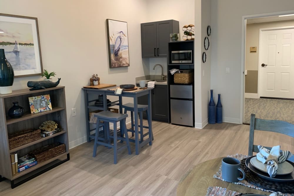 A modern kitchen with a small dining area, featuring stylish furniture and appliances.