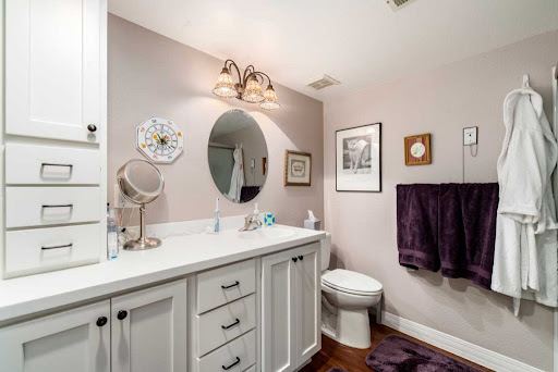 A well-decorated bathroom featuring a stylish vanity, round mirror, and elegant lighting.