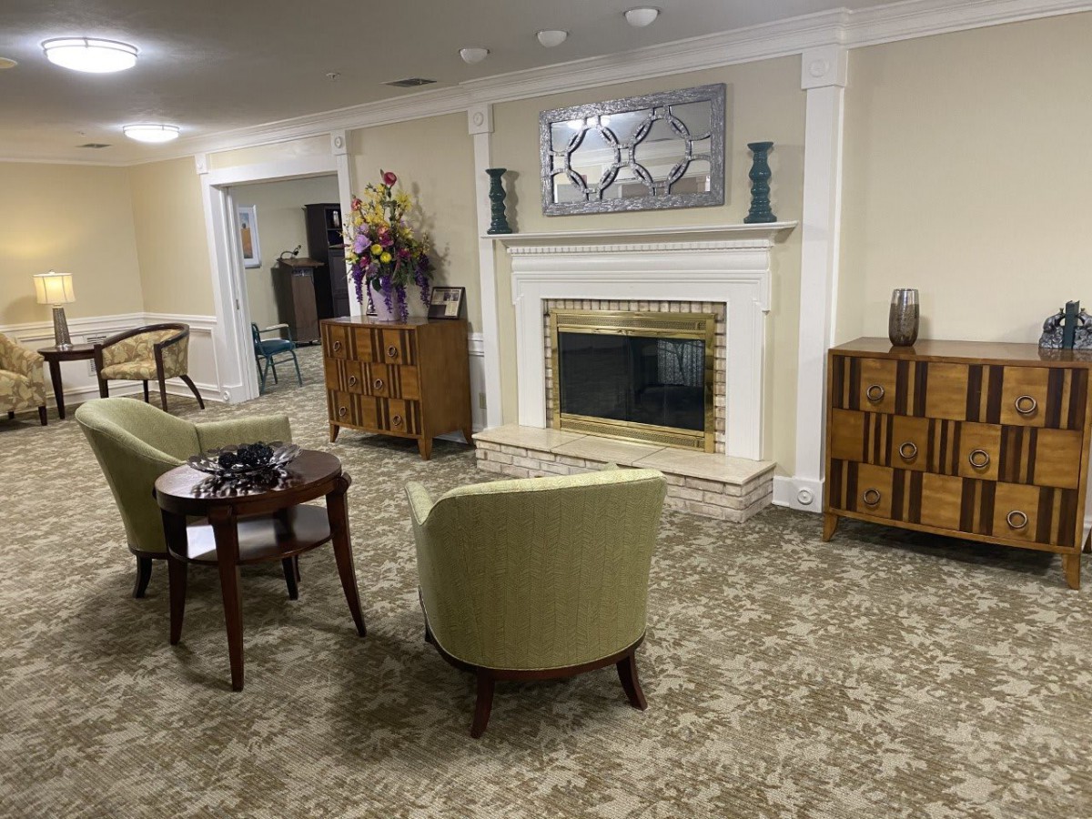 A cozy living room featuring a fireplace, armchairs, and stylish furniture.