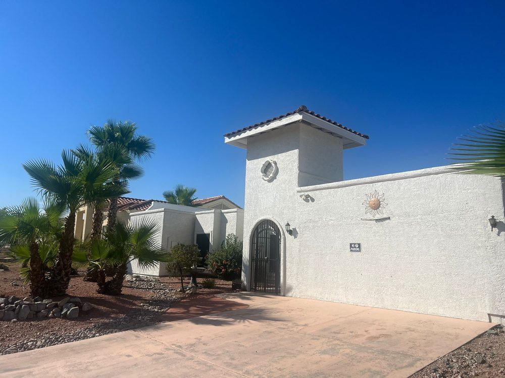 A sunny day at a modern residence surrounded by palm trees and desert landscaping.
