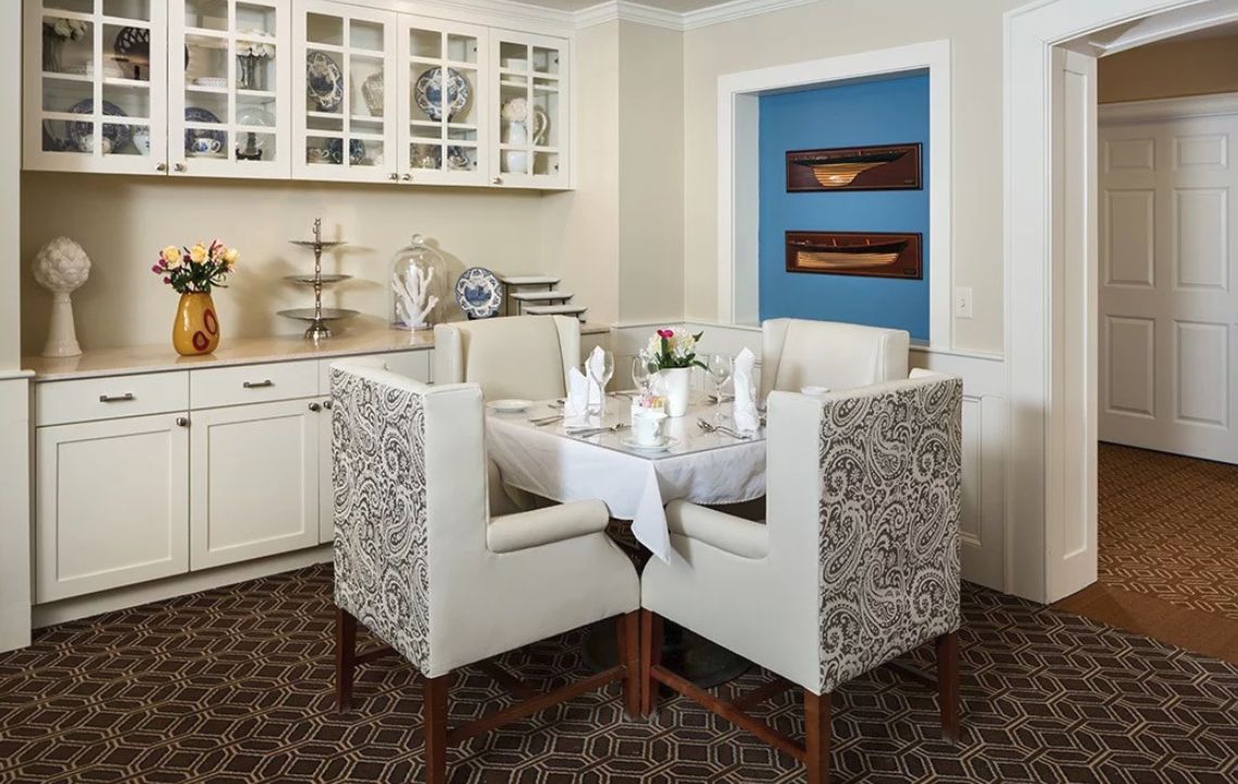 A cozy dining area with elegantly upholstered chairs and a beautifully set table, featuring modern decor elements.
