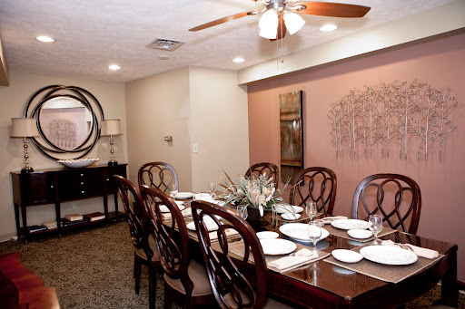 A beautifully arranged dining room featuring a long wooden table set with dishes and elegant decor.