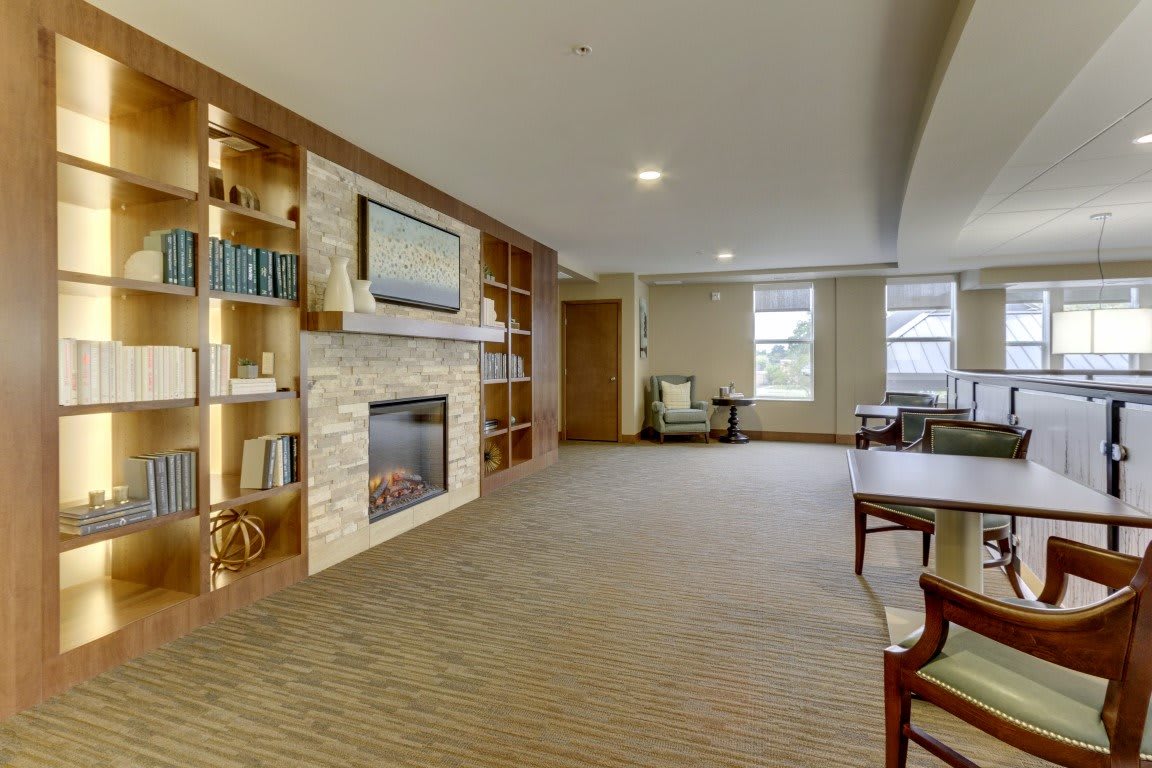 A modern living room with a fireplace, built-in bookshelves, and a carpeted floor.