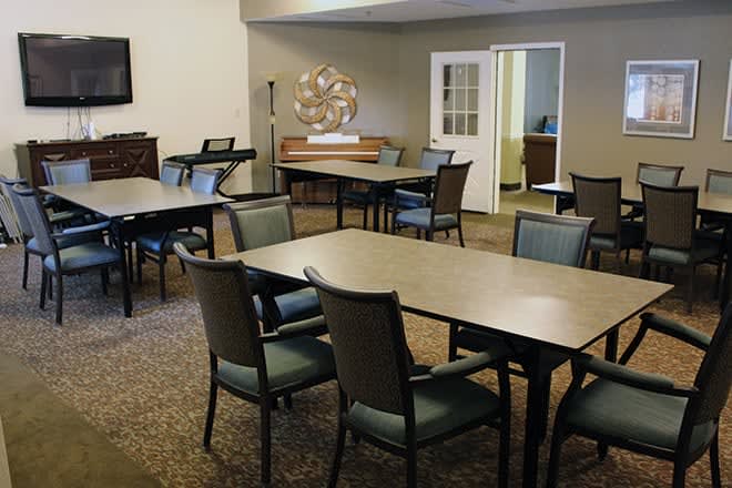 A conference or meeting room with multiple tables and chairs arranged for group discussions.