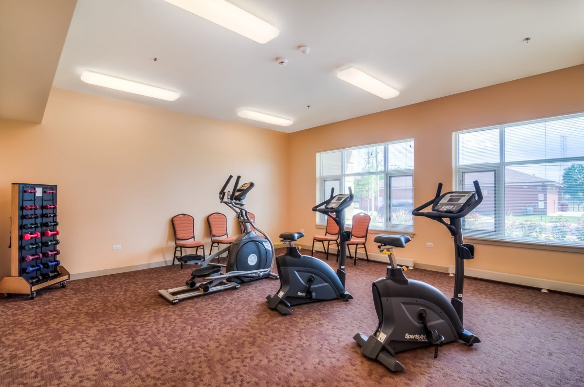 A small fitness room with various cardio exercise machines.
