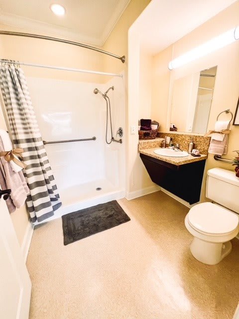 A modern and clean bathroom with a shower, sink, and toilet.