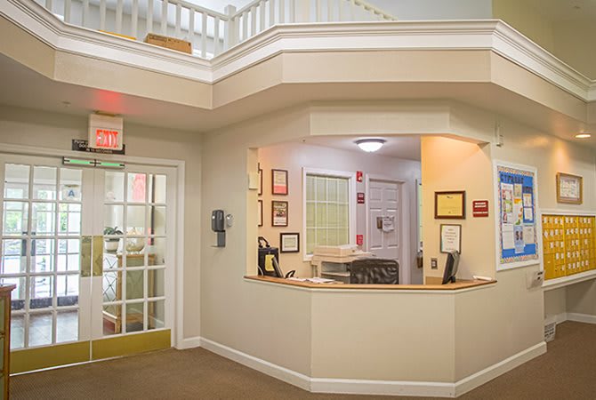 A reception area with a desk and adjacent office space.