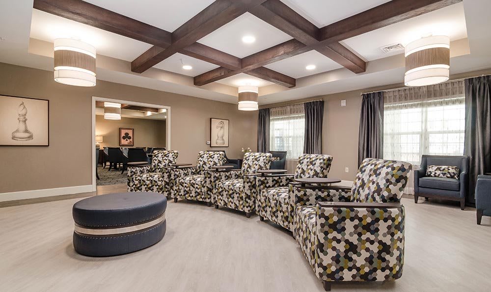 A modern living room with patterned chairs and a coffered ceiling.