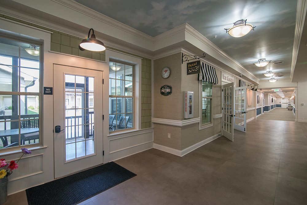 A well-lit hallway with doors and windows, showcasing interior decor and architectural elements.