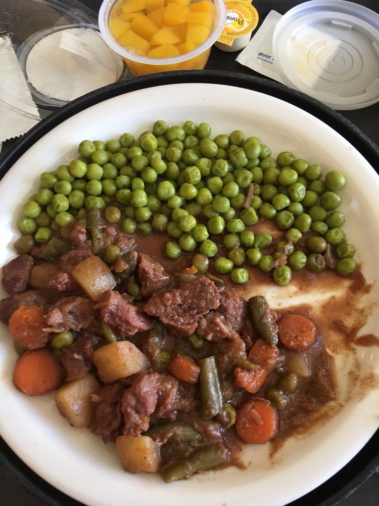 A hearty beef stew served with peas and vegetables.