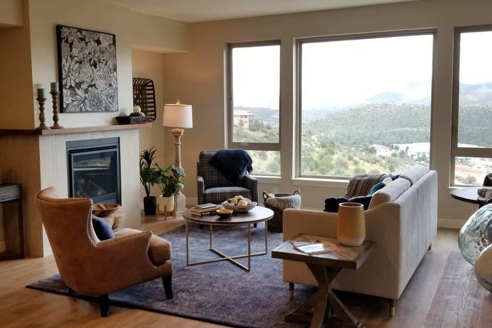 A cozy living room with modern furnishings and a stunning mountain view through large windows.