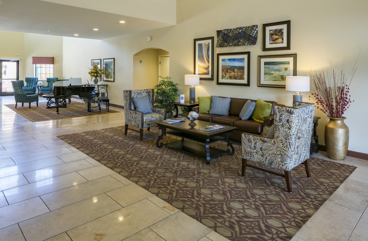 A well-decorated hotel lobby with comfortable seating and framed artwork on the wall.