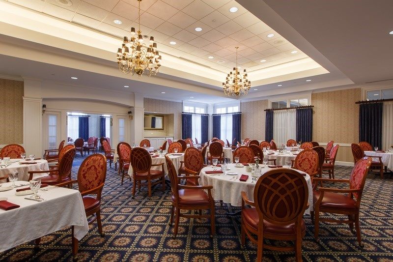 An elegantly decorated dining room with chandeliers, set up for a banquet.