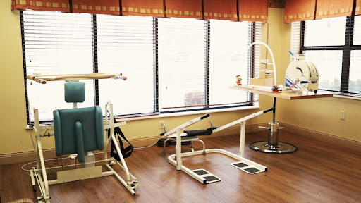 A physical therapy treatment room featuring exercise equipment.