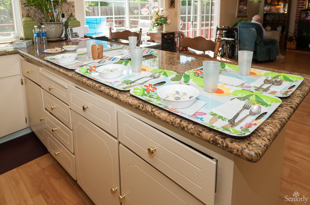 A kitchen counter with table settings prepared on colorful placemats.