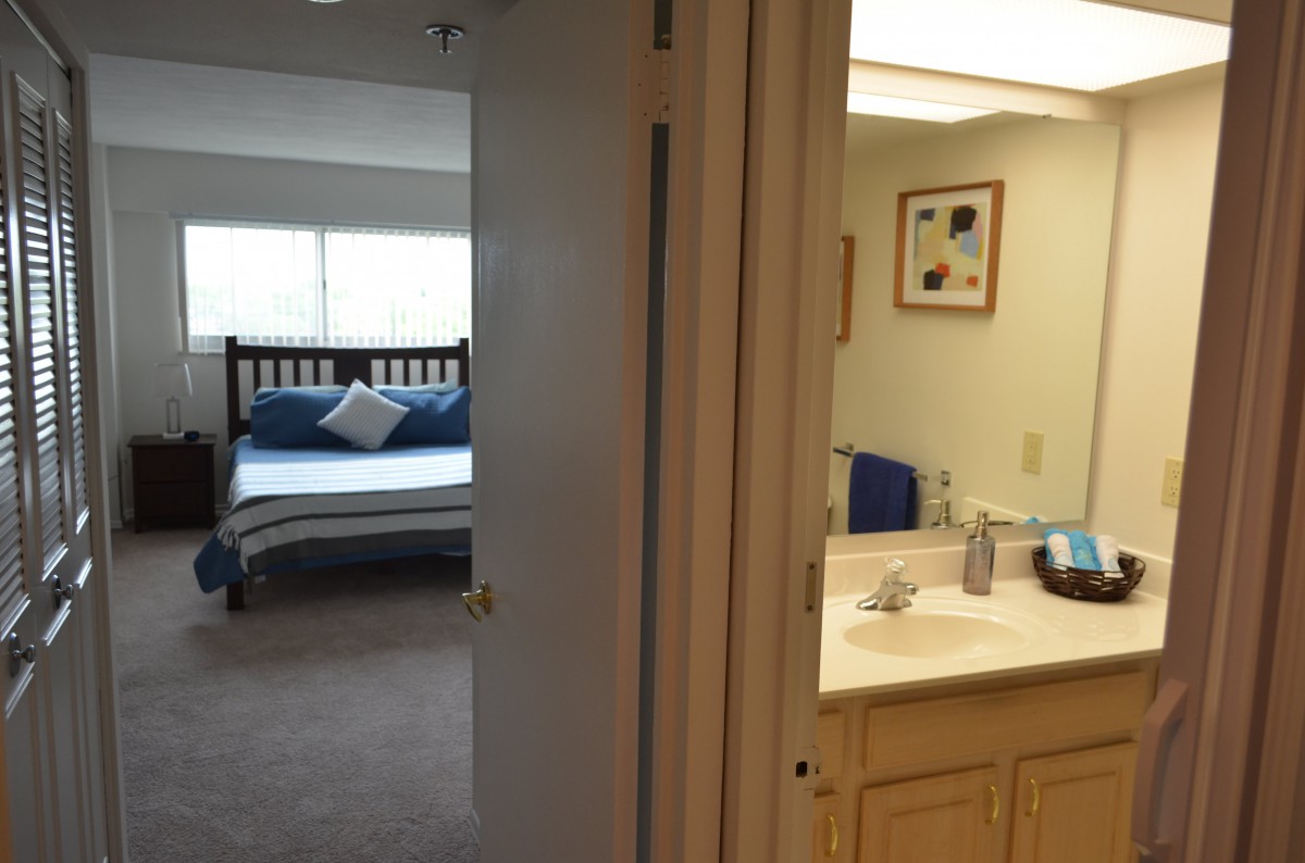 A view of a bedroom with an adjacent bathroom.