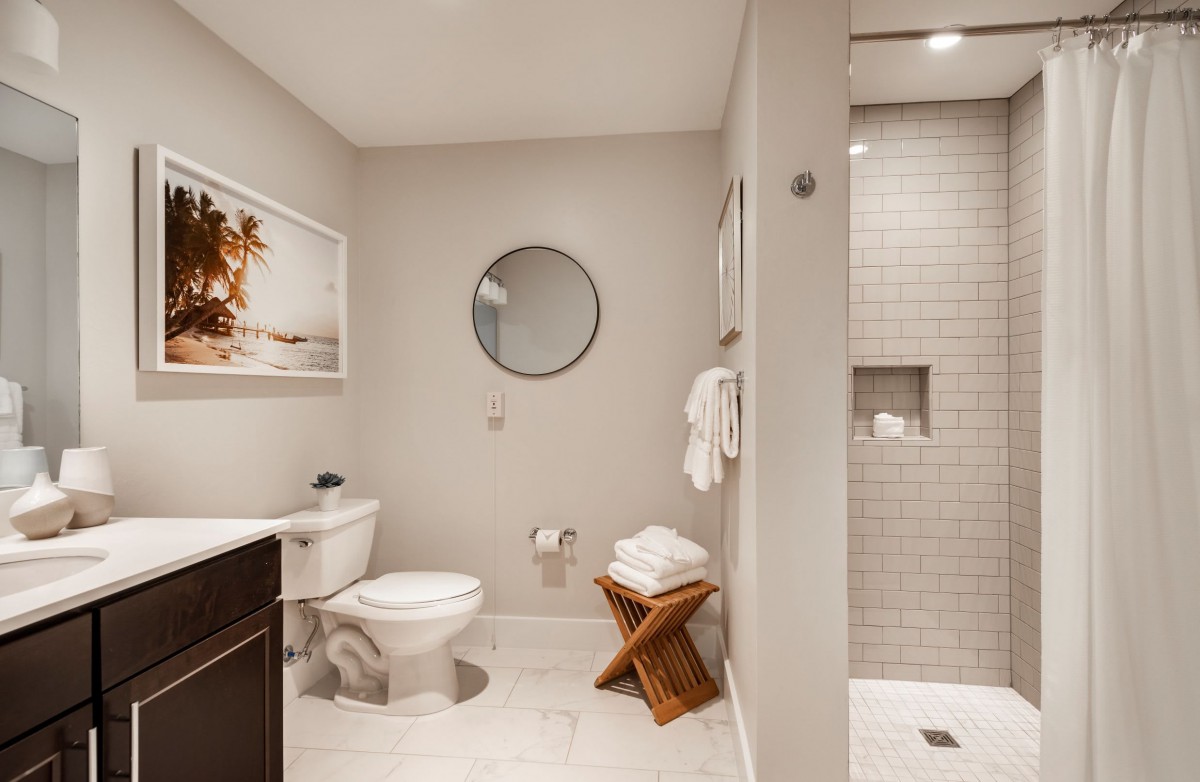 A modern bathroom with a shower, toilet, and minimalist decor.