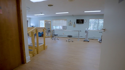 A spacious physical therapy room equipped for rehabilitation exercises.