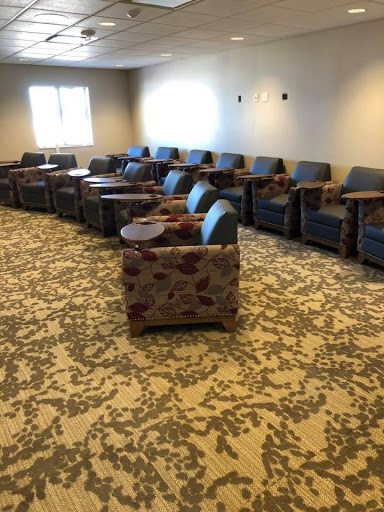 A cozy seating area featuring multiple chairs with side tables, perfect for relaxation or waiting.