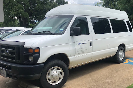 A white passenger van parked on a paved surface, ready for transportation.