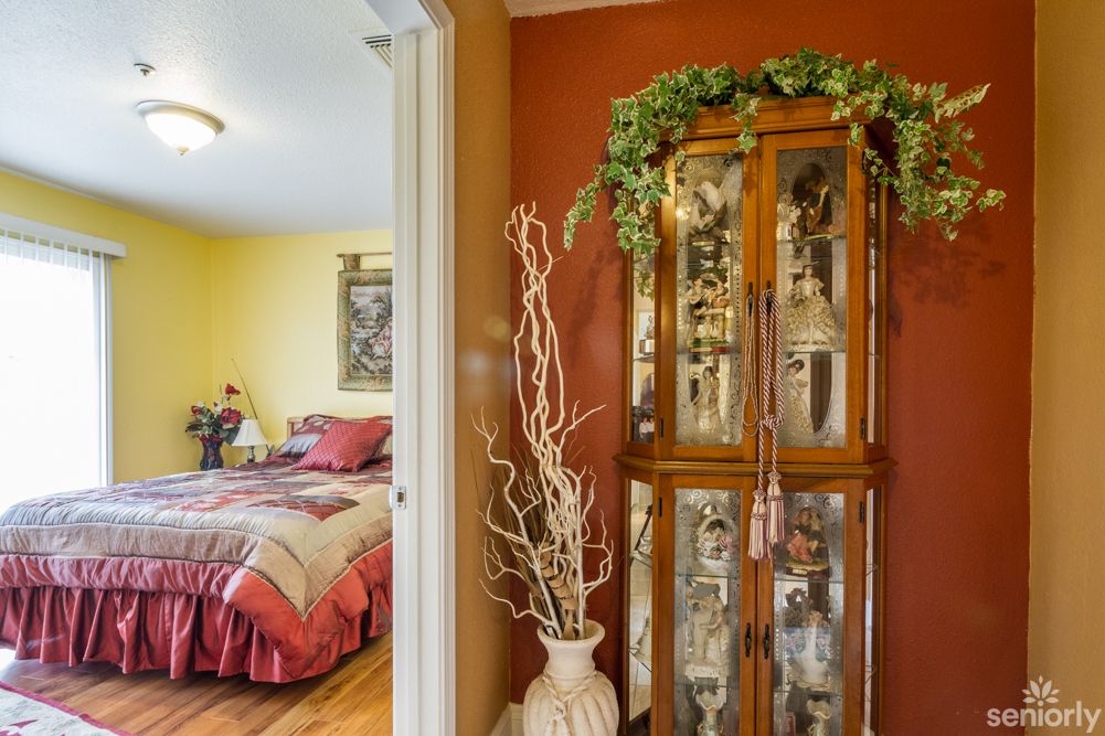 A cozy bedroom with vibrant colors and a decorative curio cabinet.