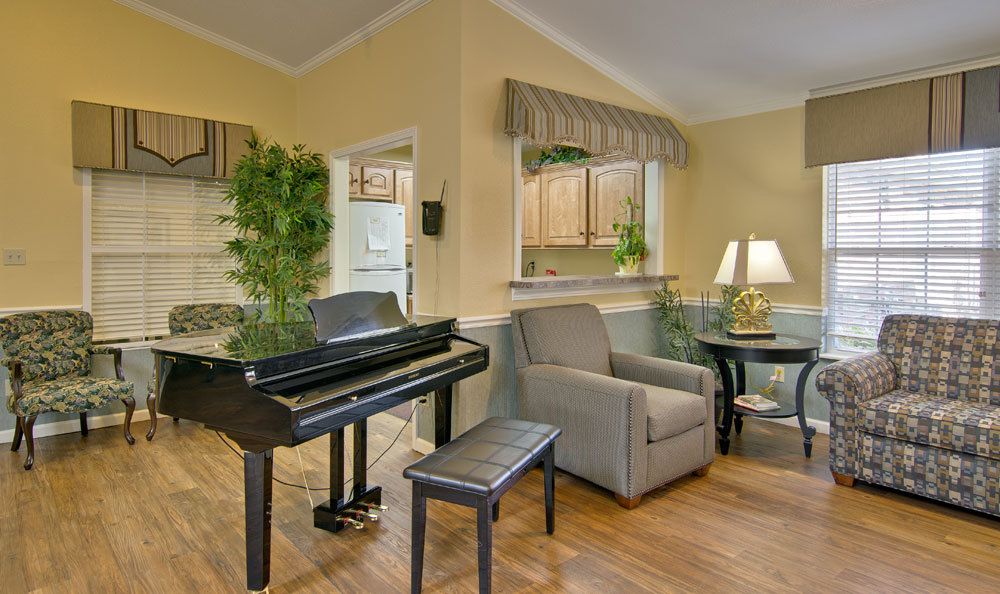 A cozy living room with a grand piano and comfortable seating.
