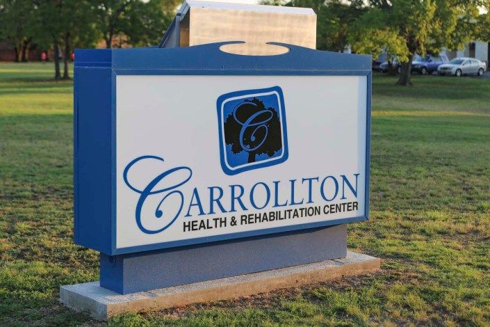 Sign for Carrollton Health & Rehabilitation Center in an outdoor setting.