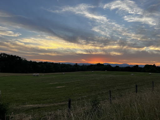 A serene sunset illuminating the sky over a peaceful field.