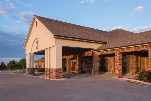 A commercial building with a covered entrance and brick facade.