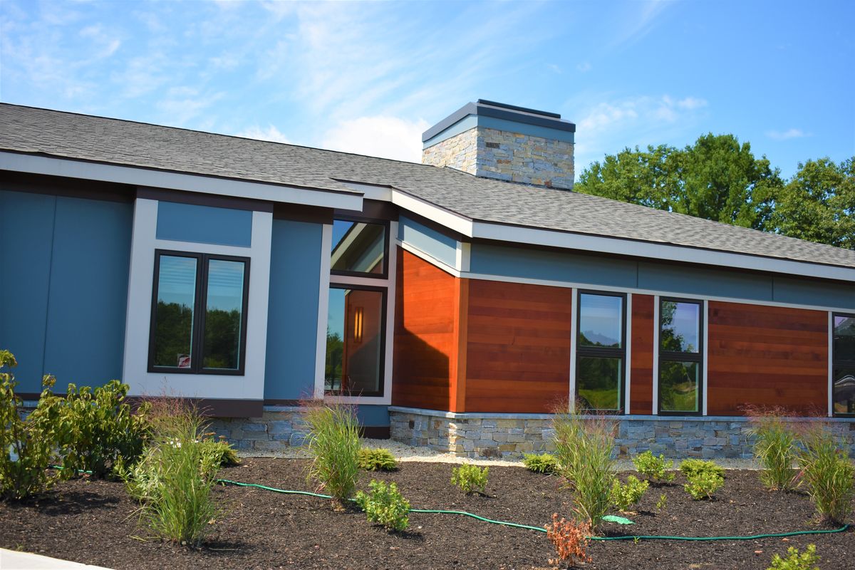 Modern house with large windows and contemporary landscaping.