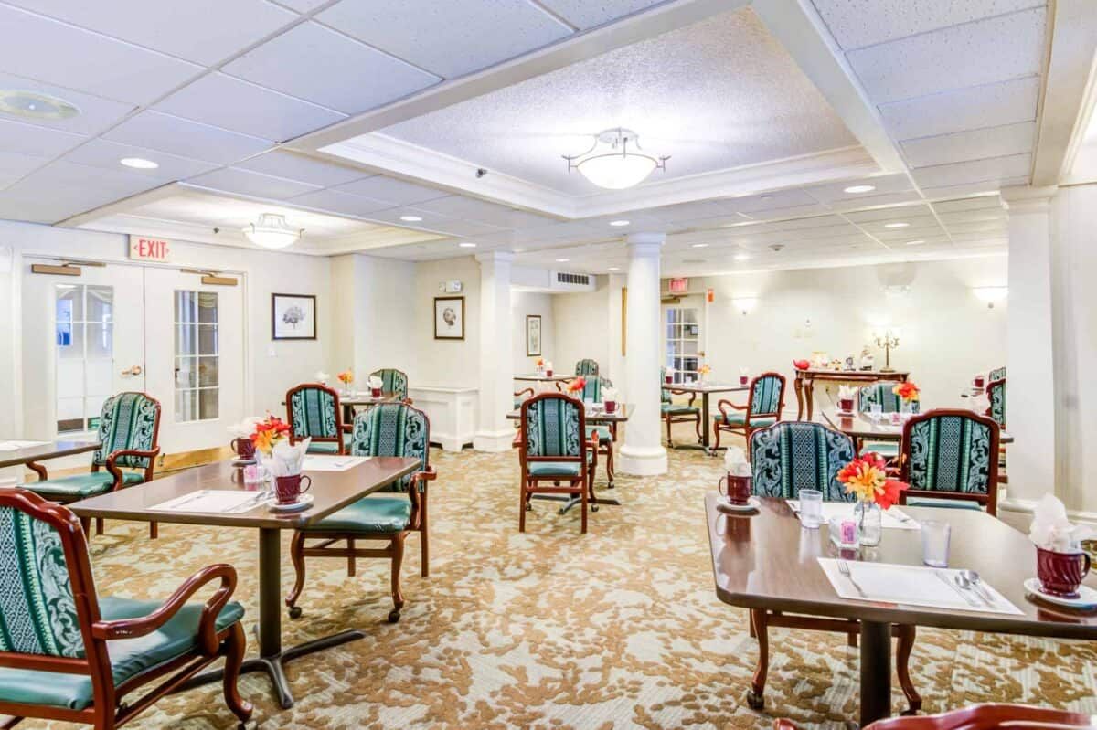 A well-lit dining room with neatly arranged tables and chairs, featuring elegant decor.