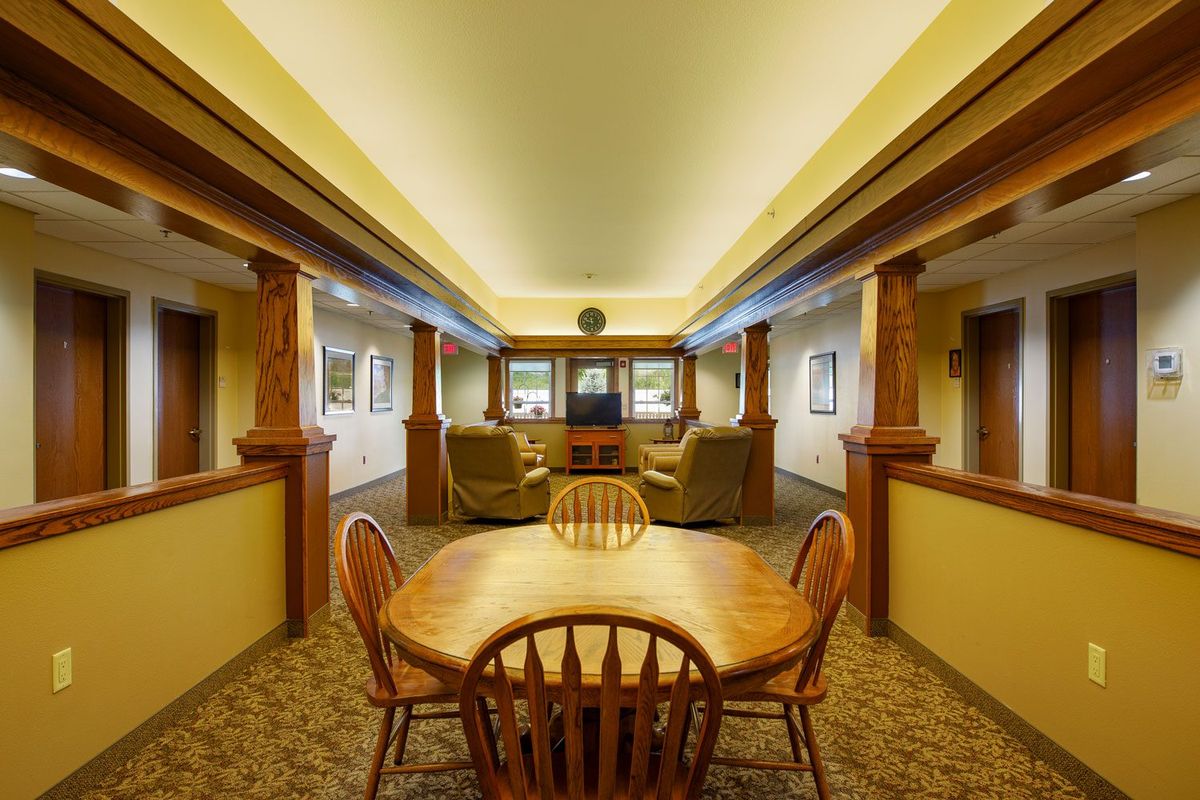 A cozy interior featuring a dining area with wooden furniture and warm lighting.