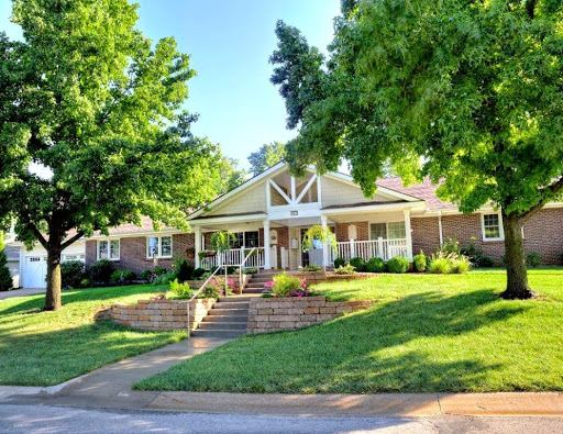 A charming residence featuring well-maintained landscaping and inviting steps leading to the entrance.