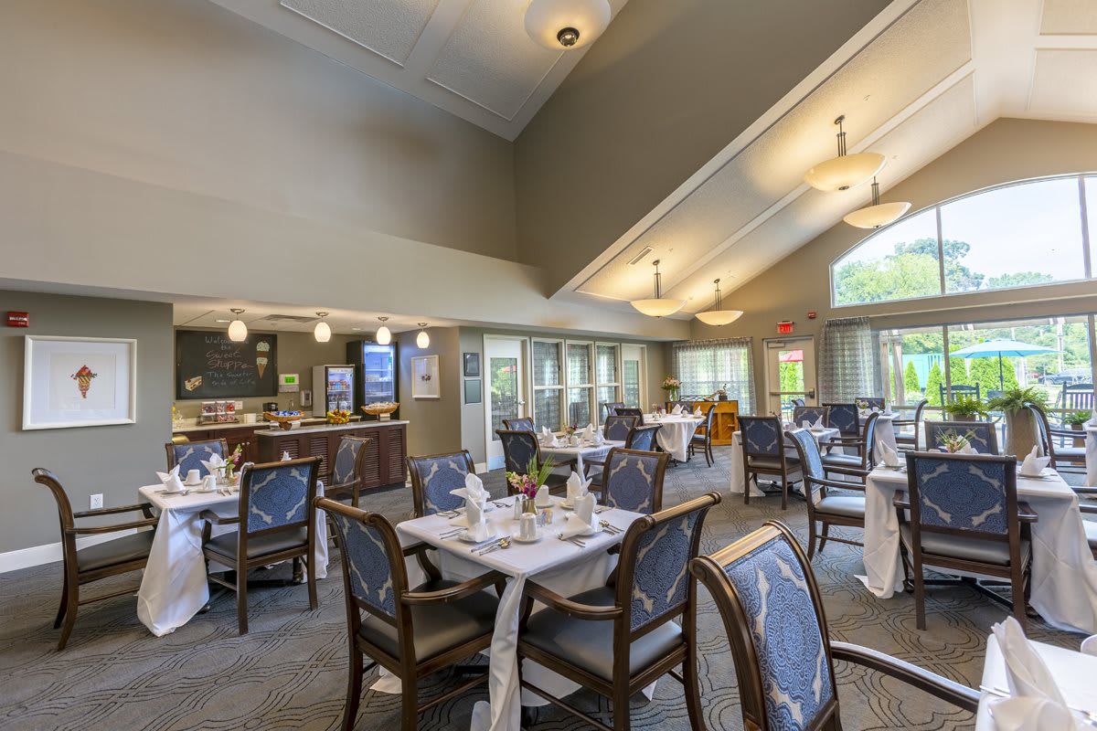 A spacious indoor dining area with set tables and elegant lighting.
