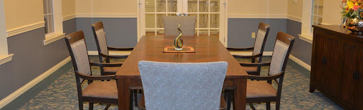 A modern dining room setup featuring a wooden table, stylish chairs, and a decorative centerpiece.
