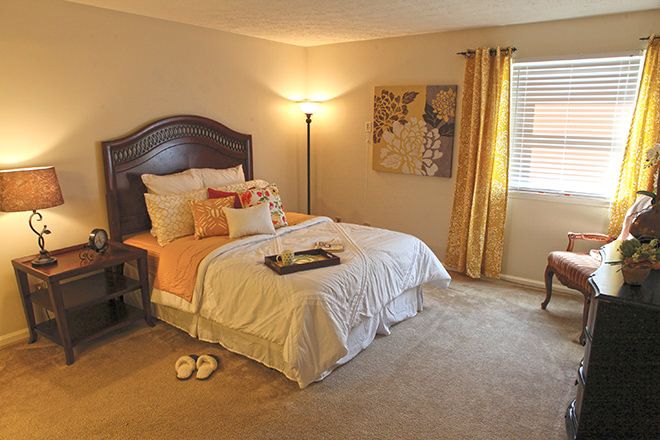 A cozy bedroom with a neatly made bed, soft lighting, and warm decor.