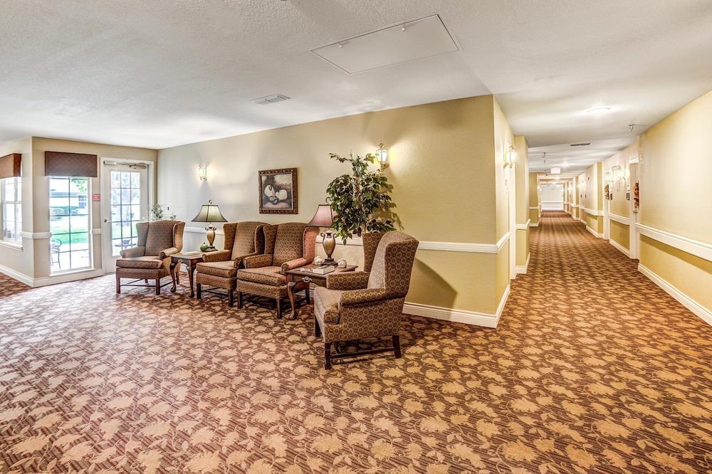 A cozy lobby area featuring comfortable chairs, a patterned carpet, and warm lighting.