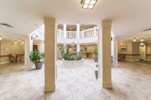 A bright and spacious lobby with columns and decorative plants.