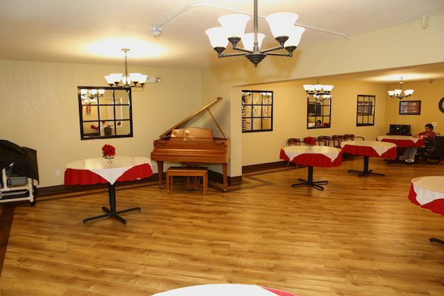 An elegant dining area with a grand piano and beautifully set tables.